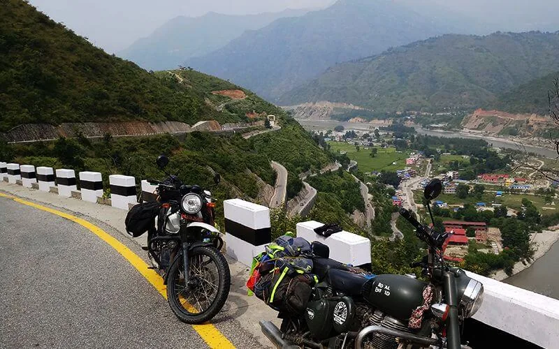 Motos sur une route dominant une vallée népalaise